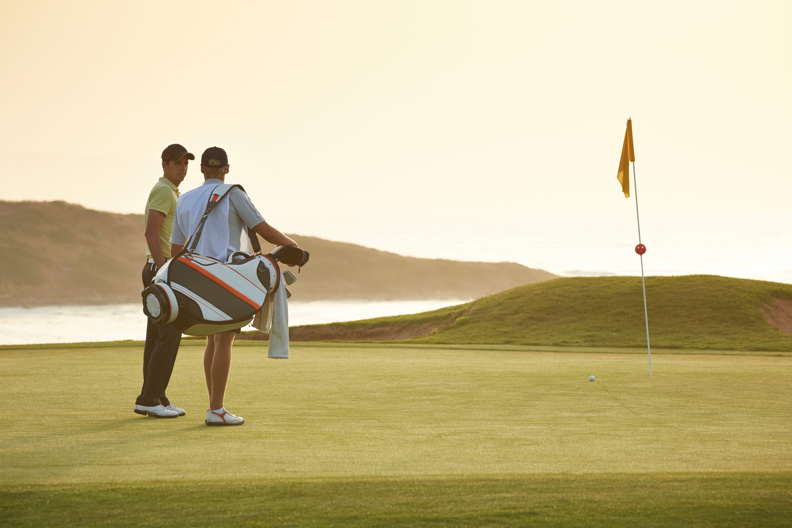 man with golf caddy on a course